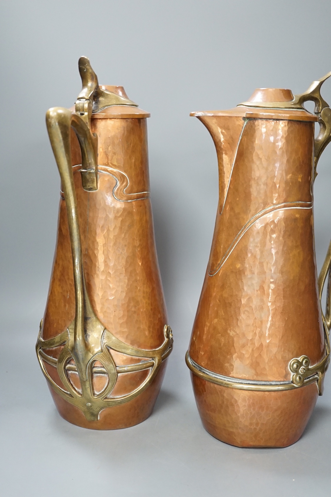 A pair of German or Austrian Jugendstil copper and brass jugs, 38cm